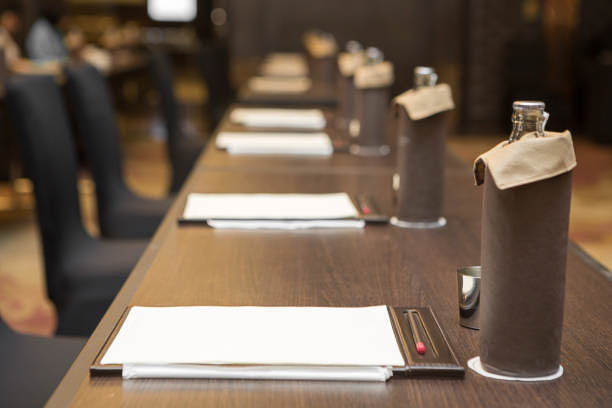 Paper, pencil, water bottle, glass on the table in the seminar room background